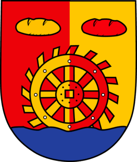 Wappen der Gemeinde Tiddische: von Rot und Gold gespalten, ein Mühlenrad über blauem Wellenschildfuß, begleitet von zwei Brotlaiben